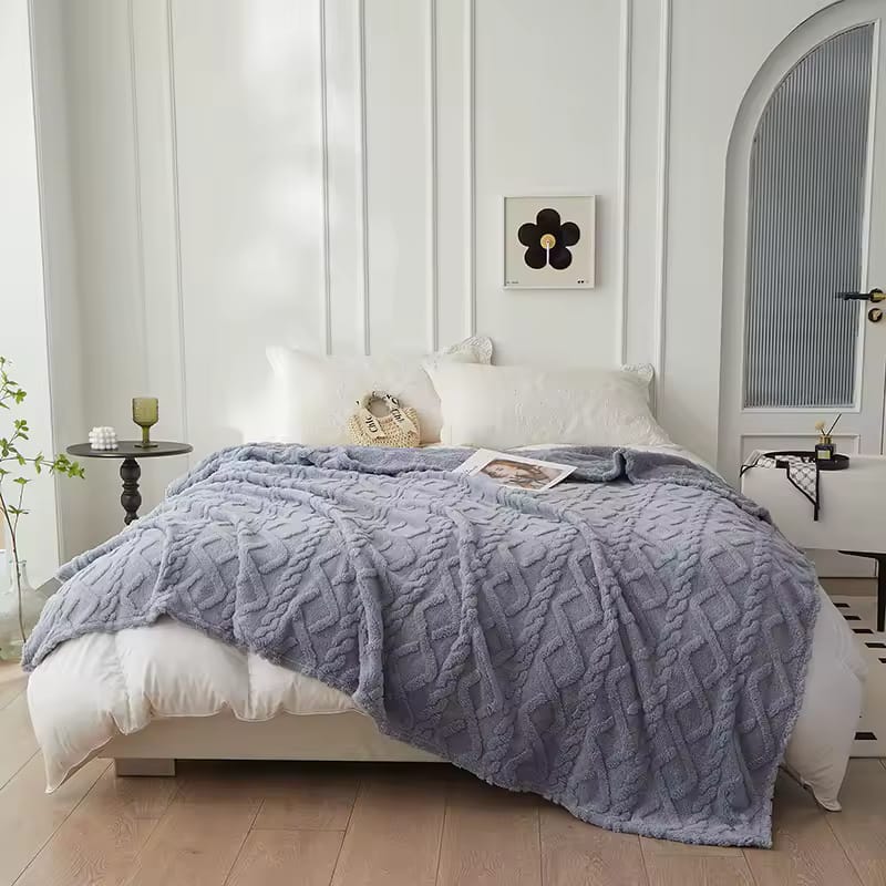 Bed with a textured purple blanket 