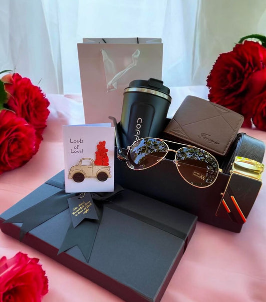 Collection of gifts including a wallet and a card on a pink surface