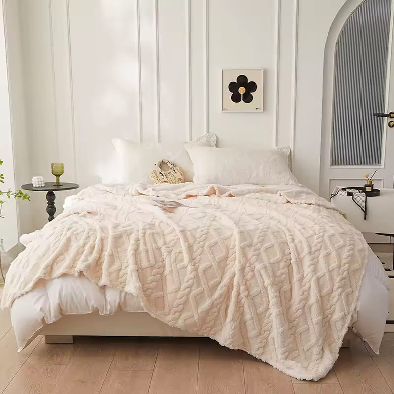 Neatly made bed with a textured beige blanket 