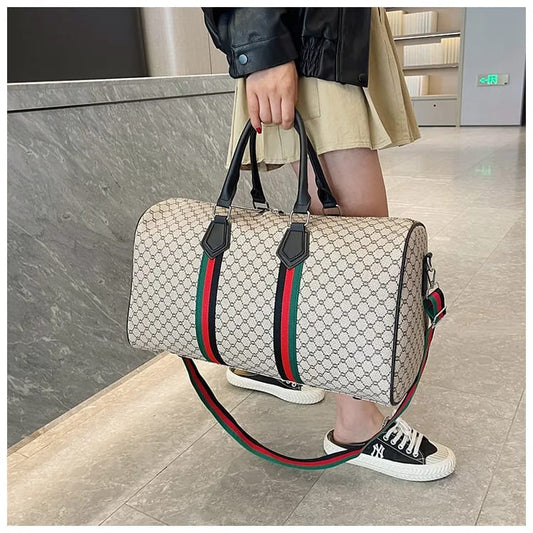 Person holding a gucci -style Duffle bag