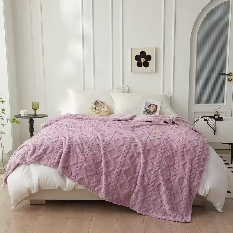 Pink textured blanket on a bed in a bedroom 