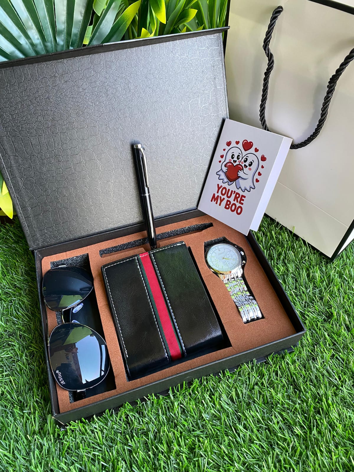 Wallet, pen and card on grass