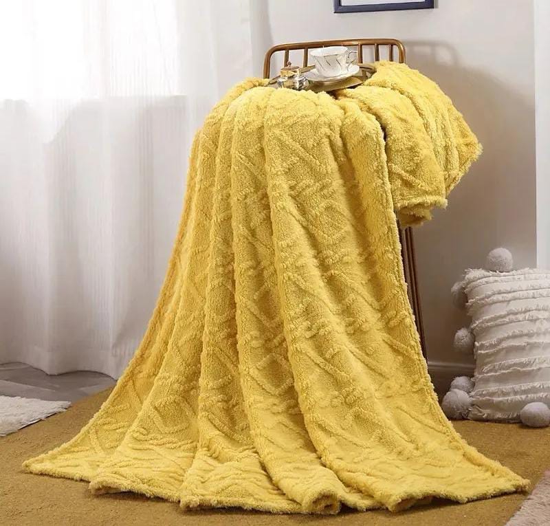 Yellow textured blanket draped over a wooden chair 