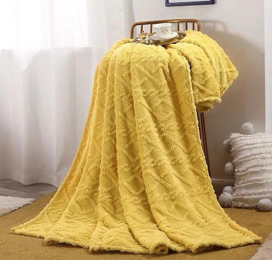 Yellow textured blanket draped over a wooden chair 